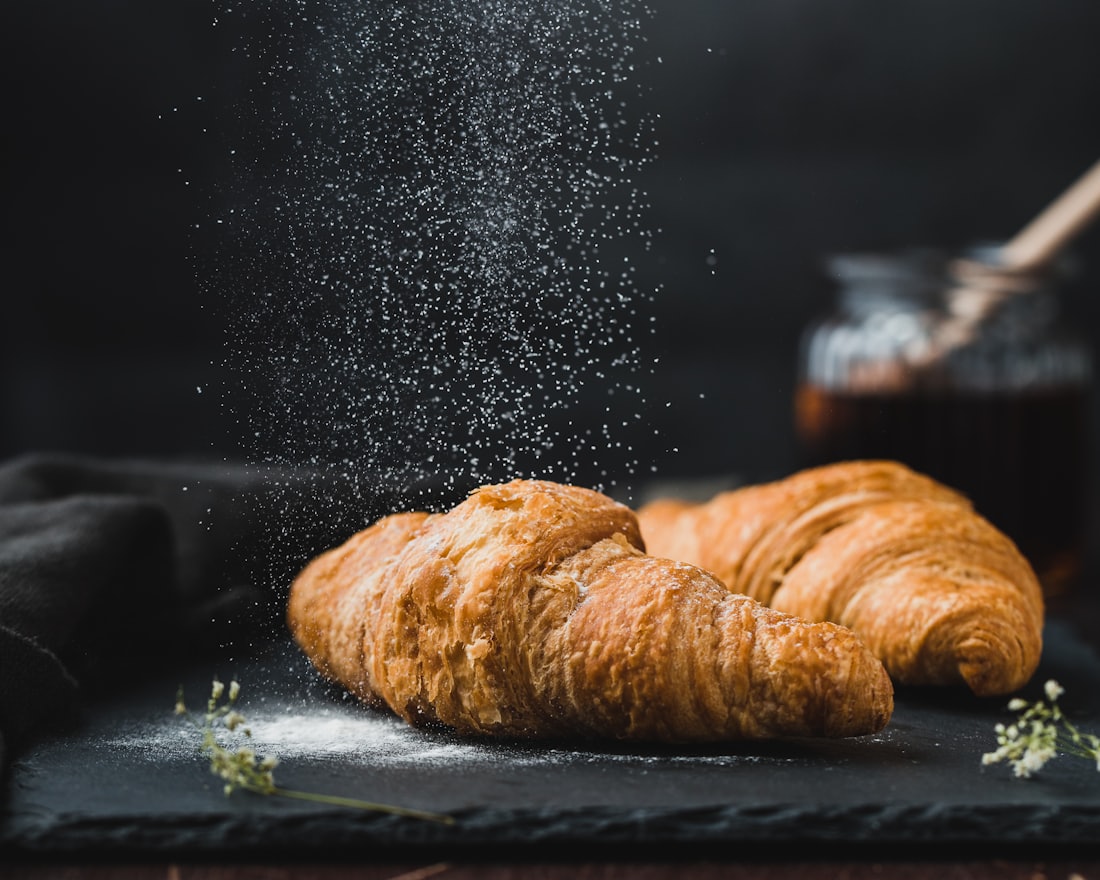 Croissants with icing sugar falling over them