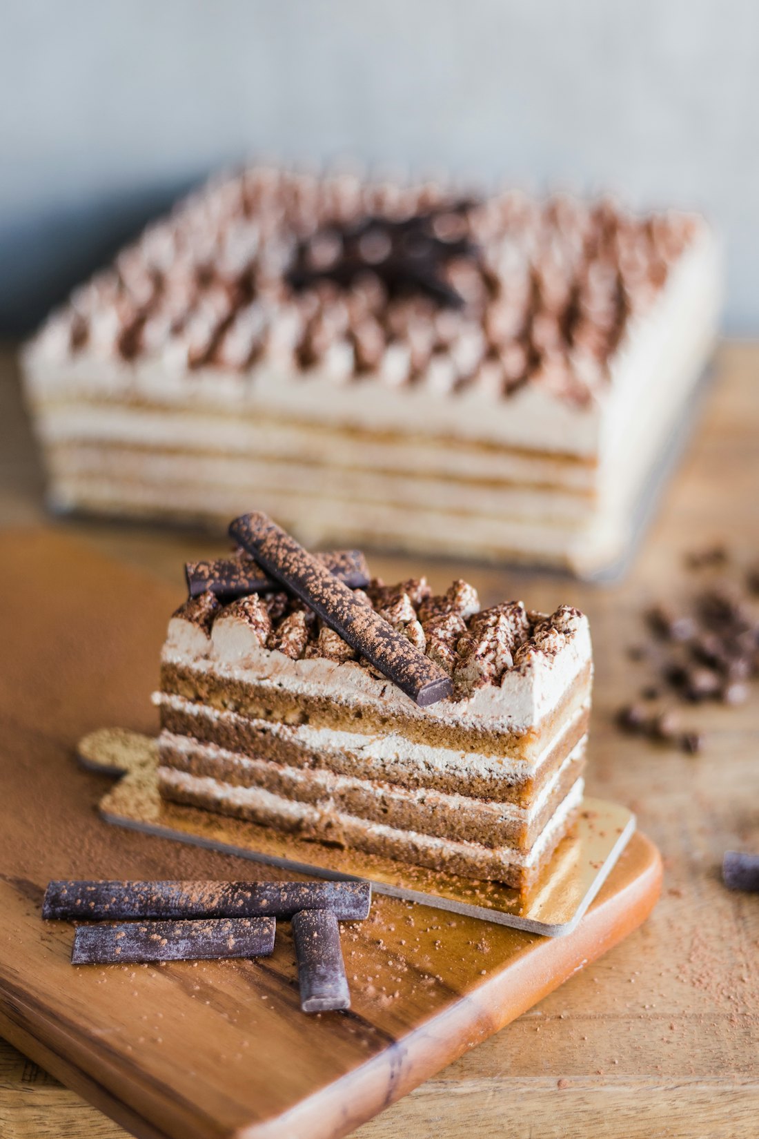 A slice of layered coffee cake on a wooden board