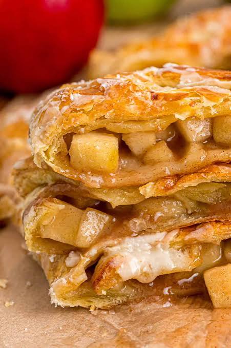 Two stacked pieces of apple strudel in glazed puff pastry, chunky apple filling showing at the cut edge